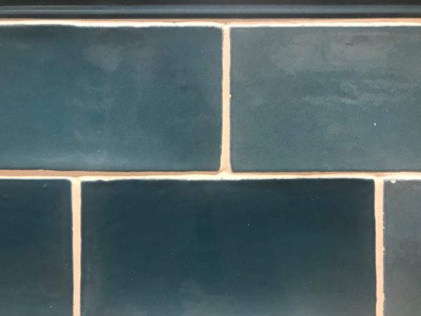 hand cut edged blue rectangular subway tile with creme grout